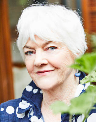 Head shot of Stephanie Alexander, white-haired woman wearing blue shirt, smiling at the camera.