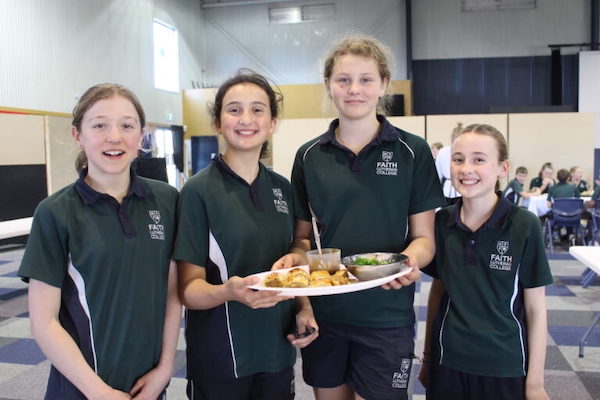 Four students showing plate of food