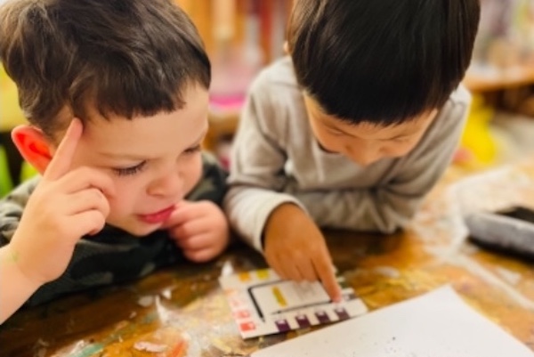 Two small children looking at pH kit