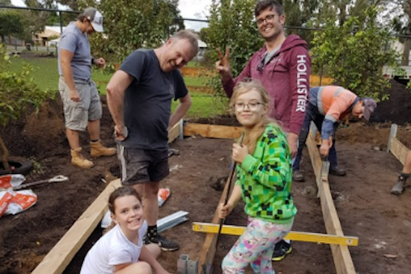 Adults and students constructing garden beds Adults and students constructing garden beds
