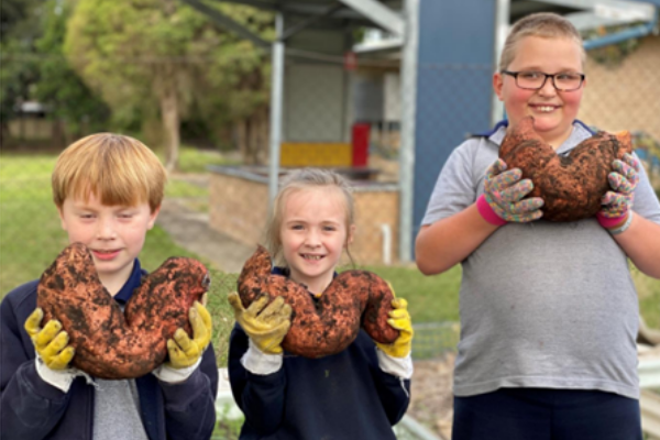 Kids holding sweet potatoes