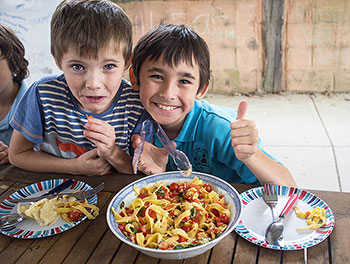 Two young male students enjoying their meals.