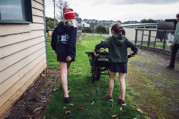 Two children pushing a wheelbarrow