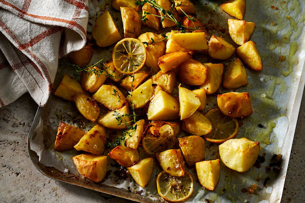 Dish of baked potatoes, cloth to left