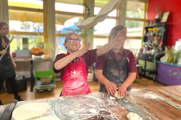 kid flipping pizza dough