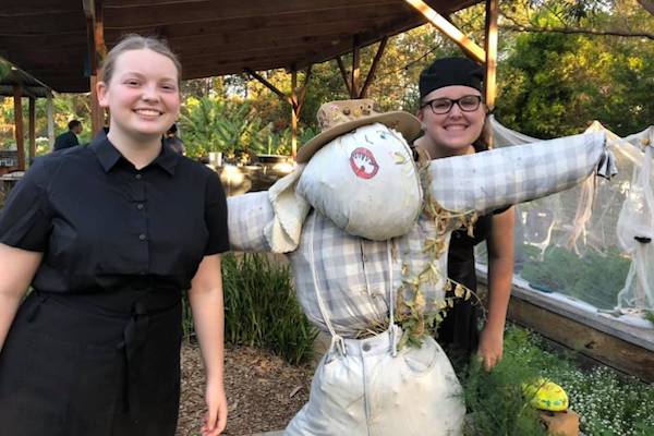 Two young people either side of a scarecrow